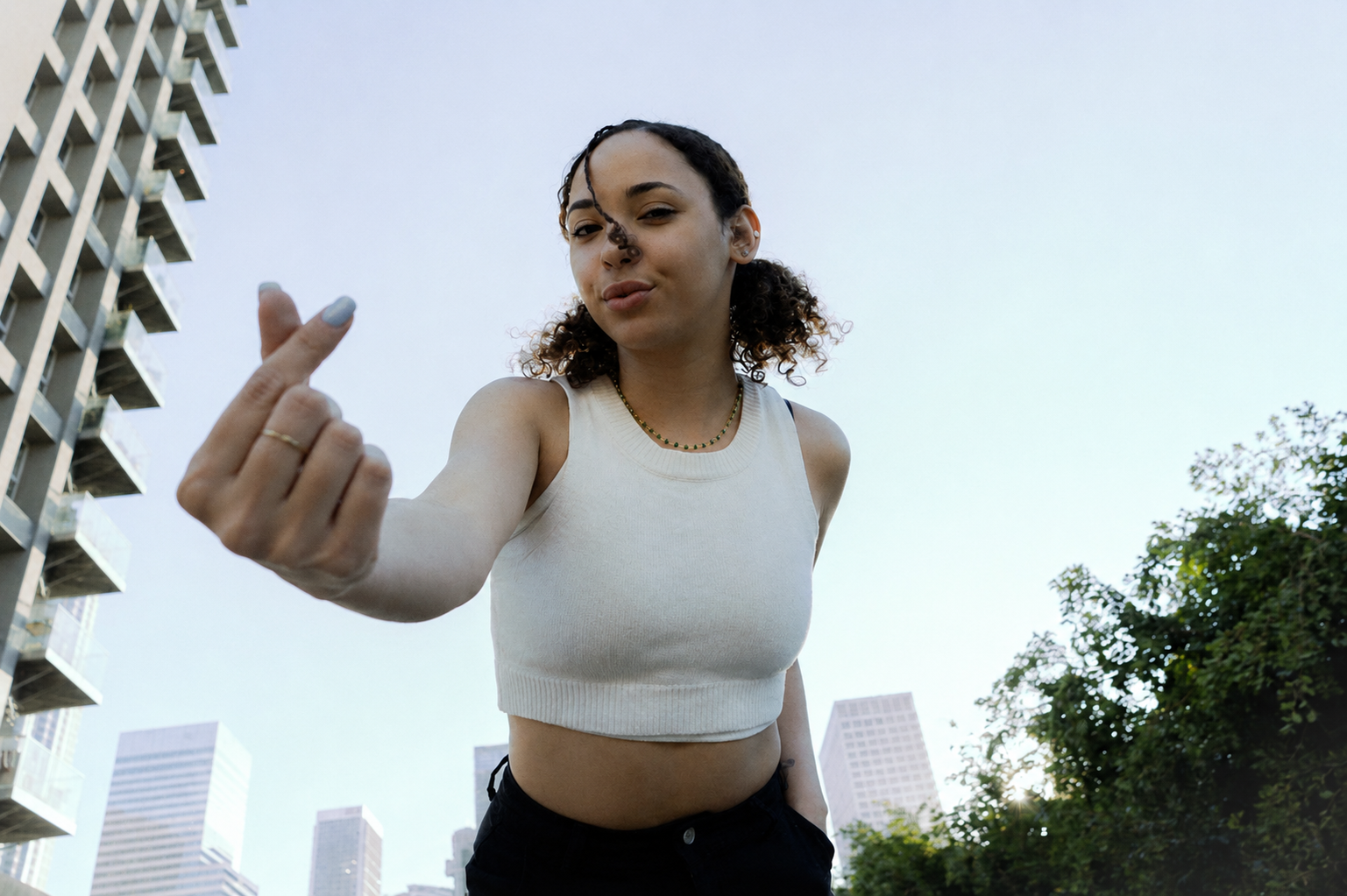 Stylish woman in a white top against a downtown Los Angeles skyline
